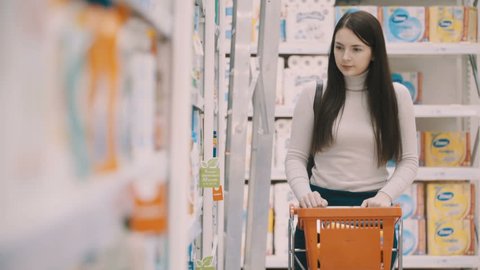 Footage young women selecting detergents for house at supermarket. 4K video
