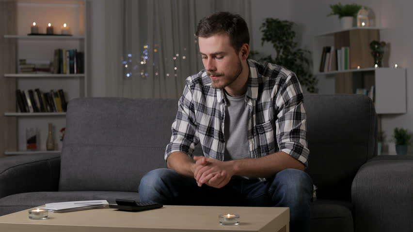 Single sad man complaining reading a letter sitting, on a couch in the night at home Royalty-Free Stock Footage #1023078406