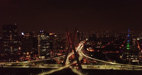 Aerial night view of The Octavio Frias de Oliveira bridge, cable-stayed bridge in Sao Paulo, Brazil over the Pinheiros River with thunder sky