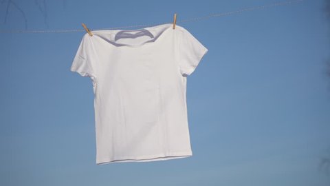 T-shirts hanging on the clothesline against blue sky