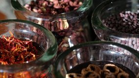 Close up footage of various spices in glass jar. Tracking shot, selective focus.