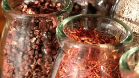Close up footage of various spices in glass jar. Panning to the right, selective focus.