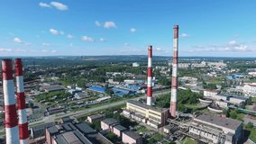 Aerial view of heat and power plant with red and white striped chimneys in industrial zone. Footage. Heavy industry