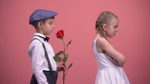 Gentleman boy with red rose apologizing to offended girlfriend, first love