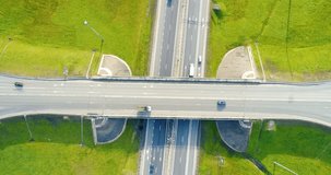 Aerial view of highway in city. Cars crossing interchange overpass. Highway interchange with traffic. Aerial bird's eye video of highway. Expressway. Road junctions. Cars in motion. Top view.