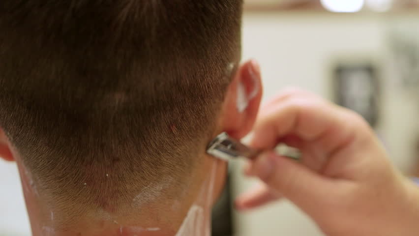 close-up of straight razor neck shave at barbershop.