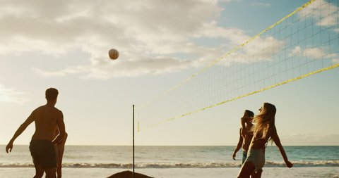 Active friends playing beach volleyball at sunset, cinematic slow motion golden light