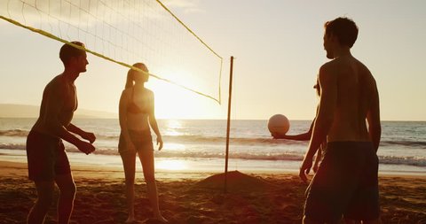 Friends playing beach volleyball at sunset, volleyball spike in slow motion cinematic