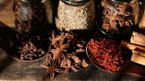 Close up footage of various exotic spices on wooden table. Selective focus. Panning to the right.