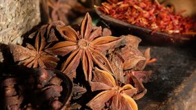 Close up footage of various exotic spices on wooden table. Selective focus. Panning to the right.