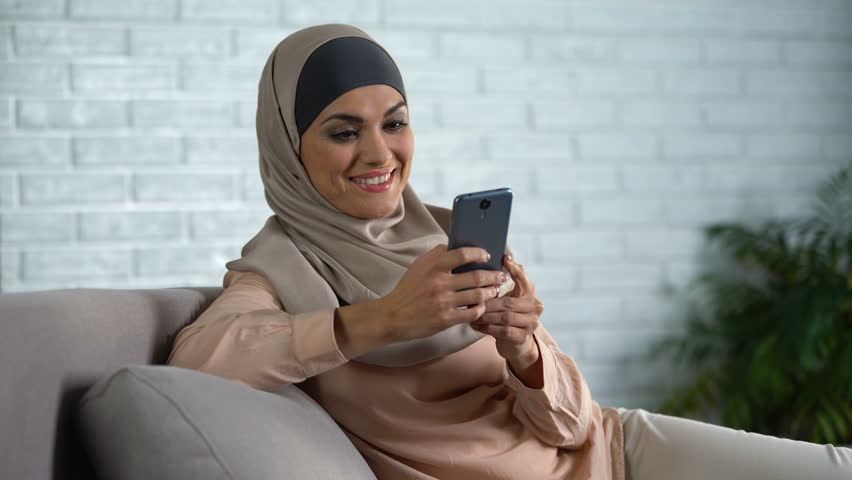 Camera arab. Smiling Muslim. Muslim with smartphone.