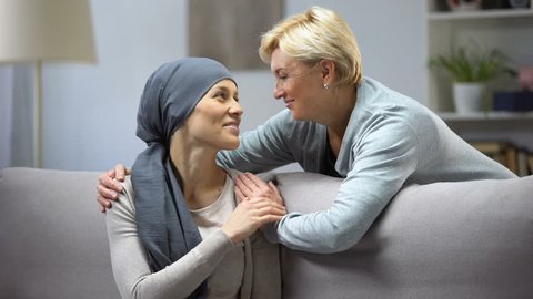 Smiling woman with cancer hugging mother, hope and togetherness, remission