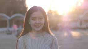Vietnamese woman. Beautiful Asian girl smile in the sunshine. Stock video footage of a pretty Asia young woman with long hair nice smiling in sun light backlit. Beautiful girl in sunlight backlight