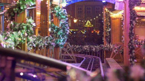 WROCLAW, POLAND - JANUARY 9, 2019: train with wooden wagons rides on rails on background of christmas lights and decoration at evening
