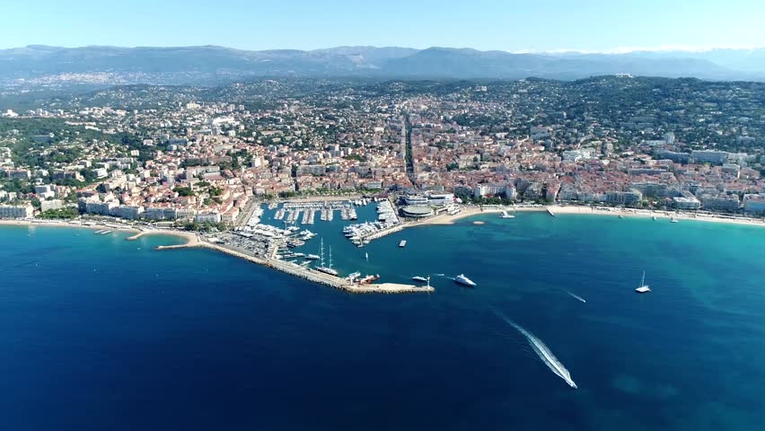 High altitude aerial shot from helicopter showing Cannes a city located on  French Riviera and host of annual Film Festival and known for its association with rich and famous 4k high resolution Royalty-Free Stock Footage #1023123610