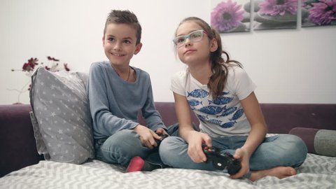 Friends playing video game fight at home. Boy and girl playing video games. Brother and sister enjoy game console. Kids have fun together