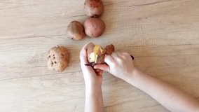 Female hands peeling potatoes with a knife. Top view. recipe dishes, home video. fast speed