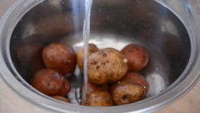 women's hands wash the potatoes in the washstand or kitchen sink under the water recipe dishes, home video