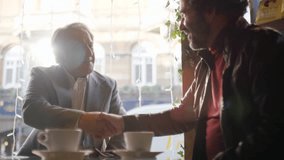 Two older men chatting shake hands, in slow motion  - Powered by Shutterstock - Get 15% off with code: PIKWIZARD15
