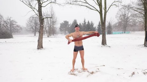Strong health man naked enjoy toweling after ice water dive snow fall in winter