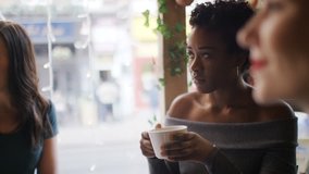Young women sat in a coffee shop in conversation - Powered by Shutterstock - Get 15% off with code: PIKWIZARD15