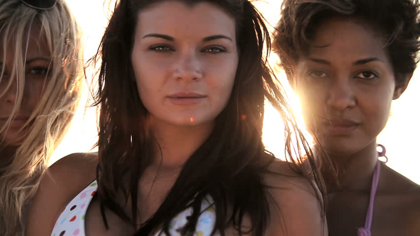 Head & shoulders of three beautiful girls wearing swimwear looking to camera