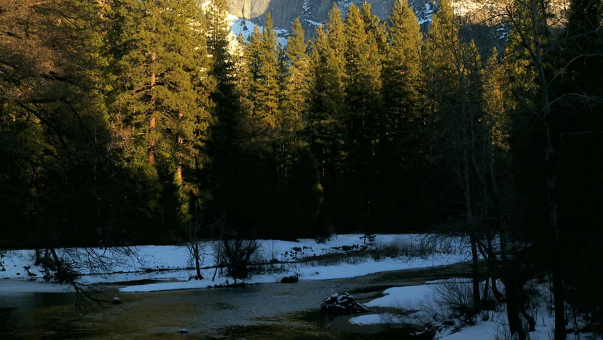 Snow capped El Capitan reflected in clear river water in Yosemite National Park in winter