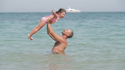 Happy family in the sea. Father and daughter play in the sea.