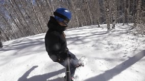 Person snowboarder snowboarding down slope 4k video, closeup with gopro view white powder snow - winter extreme sports background
