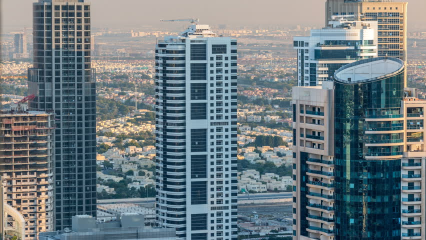 Dubai marina and skyscrapers aerial skyline during sunset timelapse. Great perspective of multiple tallest towers. Sunlight over buildings. United Arab Emirates.