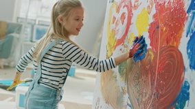 Happy Little Girl with Hands Dipped in Vivid Paint Draws Colorful Abstractions on the Wall. She is Having Fun and Laughs. Home is Being Renovated. - Powered by Shutterstock - Get 15% off with code: PIKWIZARD15