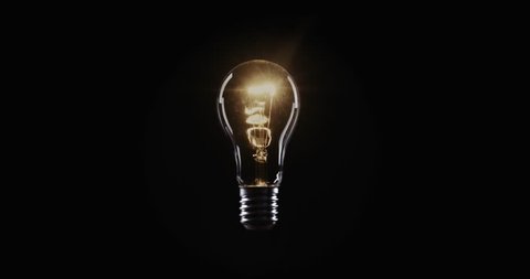 Flickering Tungsten light bulb lamp over black background