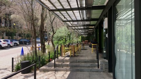 Johannesburg, South Africa - 22 January - 2019: Cafe eating area with tables outside looking on to street. Camera moves forward.