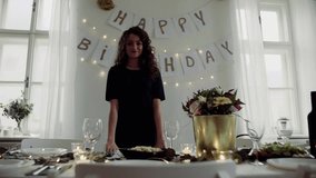 A portrait of a young woman standing indoors in a room set for a party. Slow motion. - Powered by Shutterstock - Get 15% off with code: PIKWIZARD15