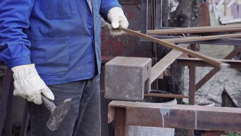 Blacksmith hammering on a metal rod