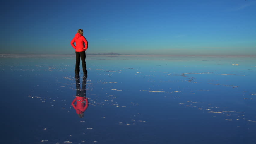 Tourist at sunset viewing the Bolivian Salar de Uyuni mineral Salt flats an Extreme Terrain Wilderness South America