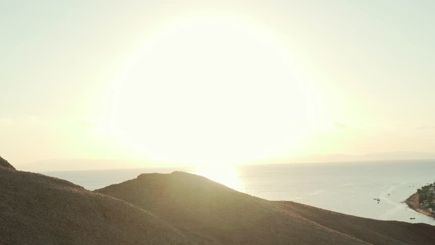 Senior traveler climb a hill to raise hands in success gesture handheld shot