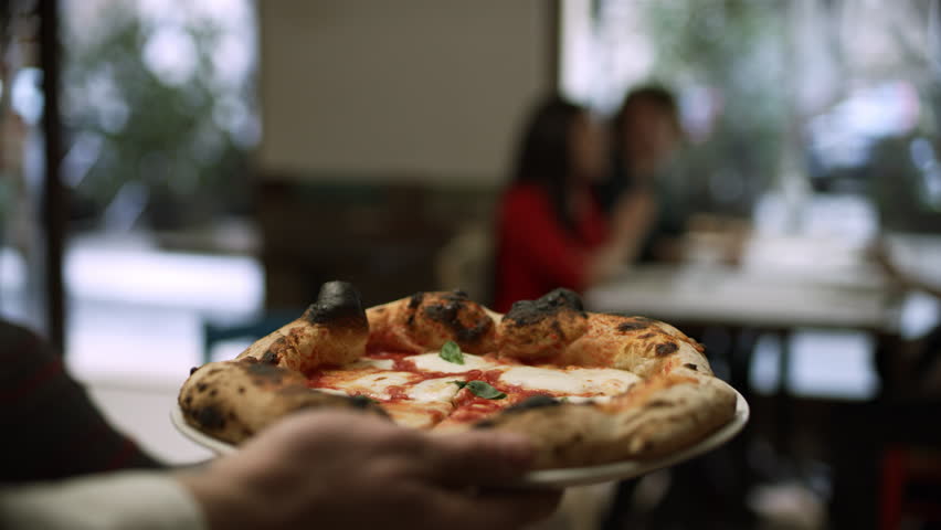 The taste of Italy! Join this group of friends and enjoy a delicious pizza in an Italian pizzeria in Rome. Close up to wide shot 8k helium RED camera. Get this shot before someone else gobbles it up! Royalty-Free Stock Footage #1023223876