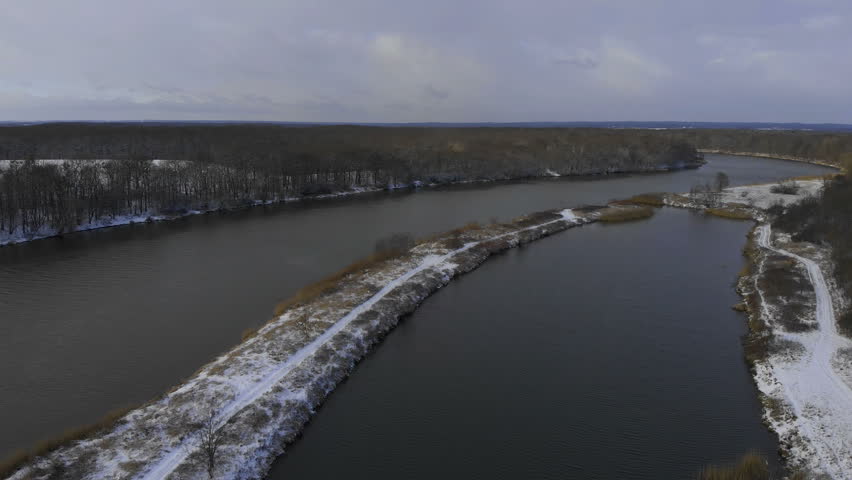 aerial view of a snowy landscape with forest and a wide river
