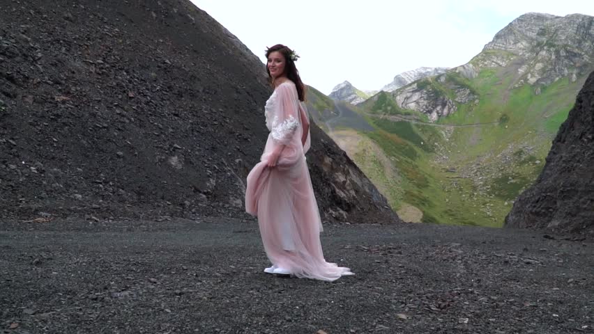 Youn boho Bride twist and dance in the mountain ladscapes.