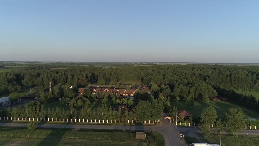 Aerial flying over a country complex located around the forest and lakes during the summer season and in sunny weather