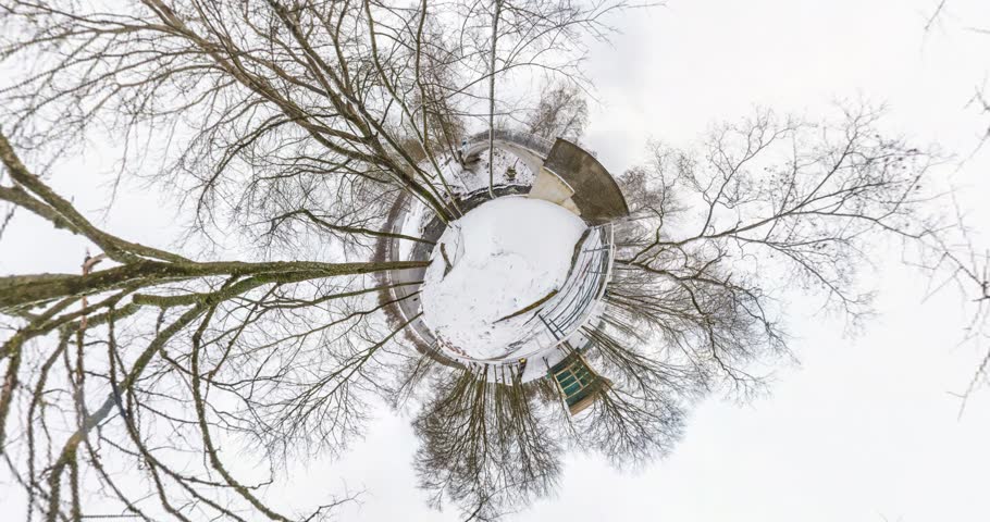 NO VR. Little planet Transformation with curvature of space. full flyby panorama with rise up into the sky of a winter landscape in city park.