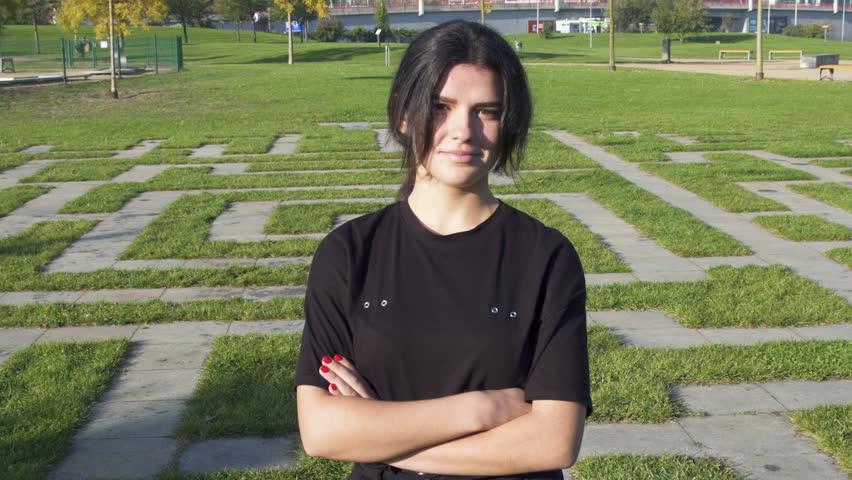Attractive  positive smiling Yong brunette teenager girl Look toward the camera and say No negative. In suny day in autumn social park