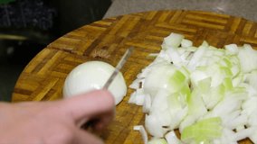 Female housewife hands slicing onion.