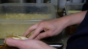 Female housewife hands peeling potatoes in the kitchen.