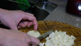 Female housewife hand chopping potatoes in the kitchen.