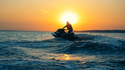 A man is sailing across the sea on his waverunner.