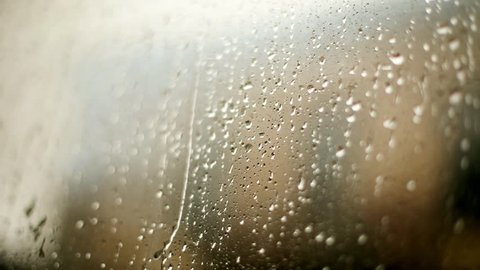 Color close up footage of rain drops on a window.