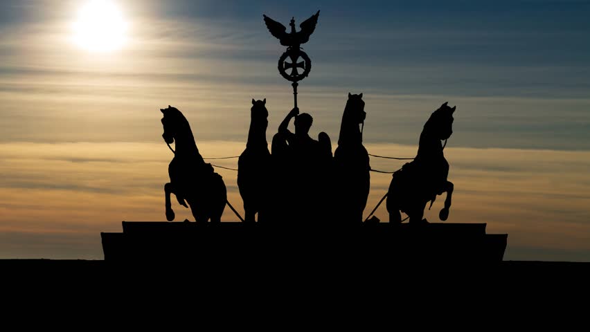 Berlin: Quadriga on Top of the Brandenburg Gate at Sunset, with Orange Sun and Clouds, Germany, Europe