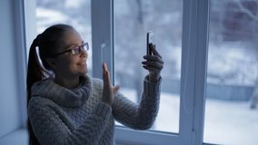 beautiful lifestyle woman uses video chat enjoying online communication with her friends and being in a new apartment on a cold winter evening